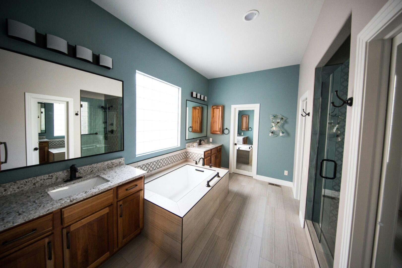 A bathroom with blue walls and wooden cabinets.
